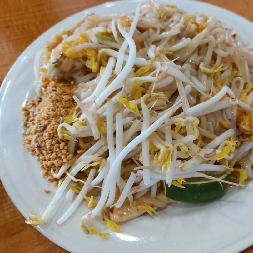 Som Jai Thai Cuisine's Pad Thai with bean sprouts, crushed peanuts, and a lime wedge.